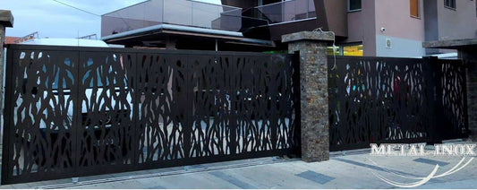 Moderna drsna kovinska vrata z abstraktnim lasersko rezanim vzorcem pred sodobno hišo – izdelek podjetja METAL-INOX